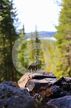 Toy dinosaur viewing a magificent outlook in nature