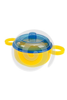 Toy dishes, a yellow saucepan with a blue lid. On a white background, isolated