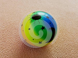 A toy for a dog or a cat, a small multi-colored balloon, drawn with the sun, moon and stars