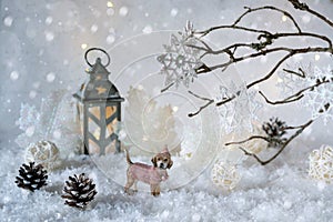 Toy dog Labrador in the frosty winter wonderland with snowfall and magic lights. New year greeting card