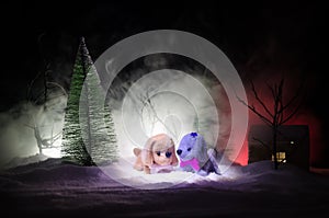 Toy dog - a symbol of the new year under the snow against the background of fir branches. Toy's dog as a symbol of 2018 New Year