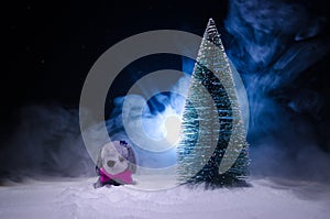 Toy dog - a symbol of the new year under the snow against the background of fir branches. Toy's dog as a symbol of 2018 New Year