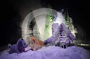 Toy dog - a symbol of the new year under the snow against the background of fir branches. Toy's dog as a symbol of 2018 New Year