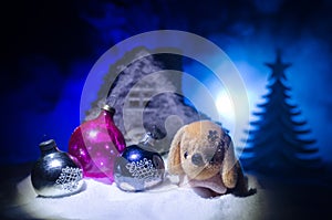 Toy dog - a symbol of the new year under the snow against the background of fir branches. Toy's dog as a symbol of 2018 New Year