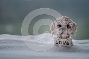 Toy dog - a symbol of the new year under the snow against the background of fir branches. Toy's dog as a symbol of 2018 New Year