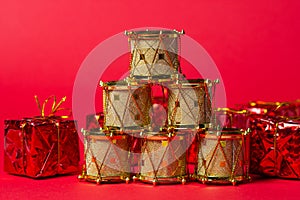 Toy drums gold color on red background. Christmas decorations on a red background. Christmas decorations.