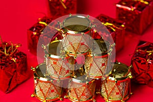 Toy drums gold color on red background. Christmas decorations on a red background. Christmas decorations.