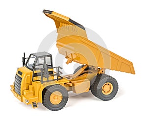 Toy dump truck with upped open-box bed side view. Children`s toy plastic haul truck car with isolated on white