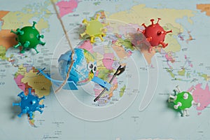 Toy of an earth fighting with an ax against viruses on a world map