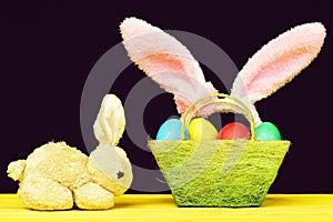 Toy Easter bunny and basket full of coloured easter eggs