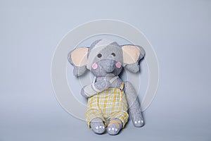 Toy elephant with bandages on light grey background