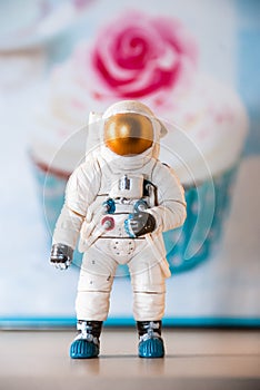 Toy figure of an astronaut, in the background of a cake