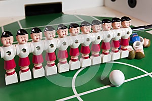 Toy football players stand on the football field, several figures have fallen, lie. Concept of excess, unnecessary people