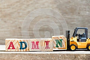 Toy forklift hold block N in word admin on wood background