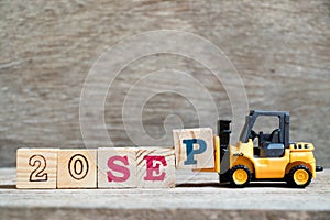 Toy forklift hold block P to complete word 20 sep on wood background Concept for calendar date in month September