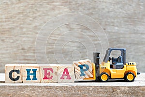 Toy forklift hold block p to complete word cheap on wood background