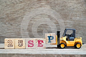 Toy forklift hold block P to word 25 sep on wood background Concept for calendar date in month September