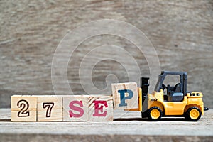 Toy forklift hold block P to word 27 sep on wood background Concept for calendar date in month September