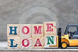 Toy forklift hold letter block E and N to complete word home loan