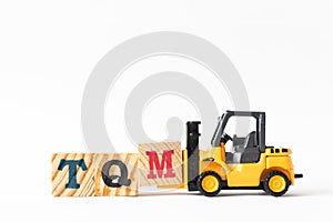 Toy forklift hold letter block M to complete word TQM Abbreviation of total quality management on white background