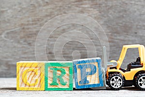 Toy forklift hold block P to complete word CRP abbreviation of C-Reactive Protein Test on wood background