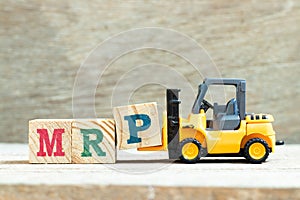 Toy forklift hold block P to complete word  MRP Abbreviation of Material requirements planning on wood background photo