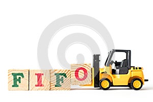 Toy forklift hold letter block to word FIFO Abbreviation of first in first out on white background