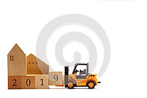 Toy forklift hold wooden letter block number 9 to complete year 2019
