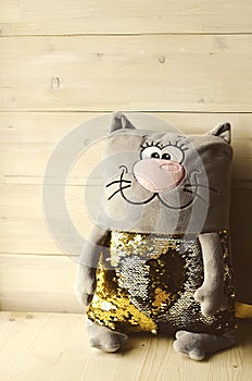Toy in the form of a cat, with sequins on the stomach.