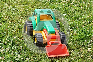 Toy green tractor on the grass.