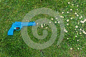 Toy gun on grass shooting daisies