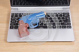 Toy gun lying on an open laptop