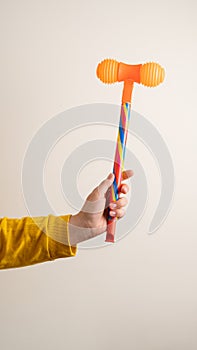 toy hammer in famele hand against light background