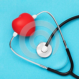 Toy heart and medical stethoscope on a blue background