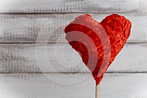 Toy heart on white rustic wooden background. St. Valentine Day symbol of love