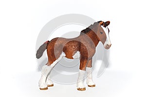 A toy horse with brown and white spots on a white background