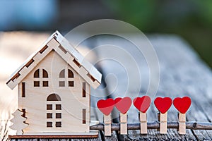 A toy house with a fence of hearts.