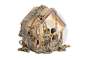 Toy house wrapped with security chains on white