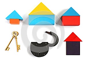 Toy houses, two golden keys and padlock, on white background