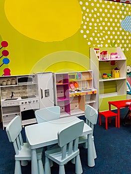 Toy kitchen, table with chairs and other toys to play in children playground indoor