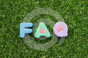 Toy letter in word FAQ Abbreviation of Frequently Asked Questions on green grass background