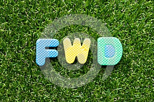 Toy letter in word FWD Abbreviation of forward on green grass background