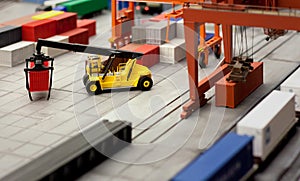 Toy loader carrying a container in a layout of a cargo hub