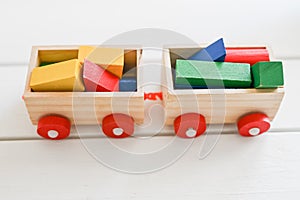 Toy locomotives trailers loaded with colored material