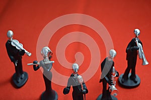 Toy Man with microphone and musicians on red background.