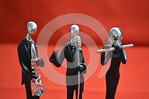 Toy Man with microphone and musicians on red background.