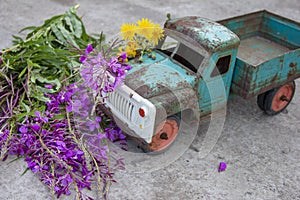 toy metal machine with traces of corrosion is on the concrete. Rust on the machine's gland