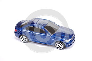 Toy model of the blue BMW 135 car of series of coupe on white background.