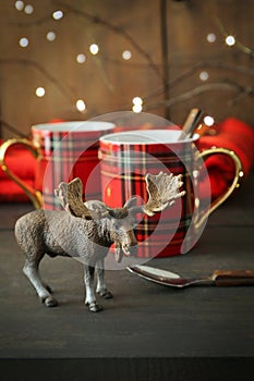 Toy moose with mugs on rustic background