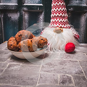Toy and `Oliebollen`, traditional Dutch pastry for New Year`s Eve. Scene at home with table and snow-covered window